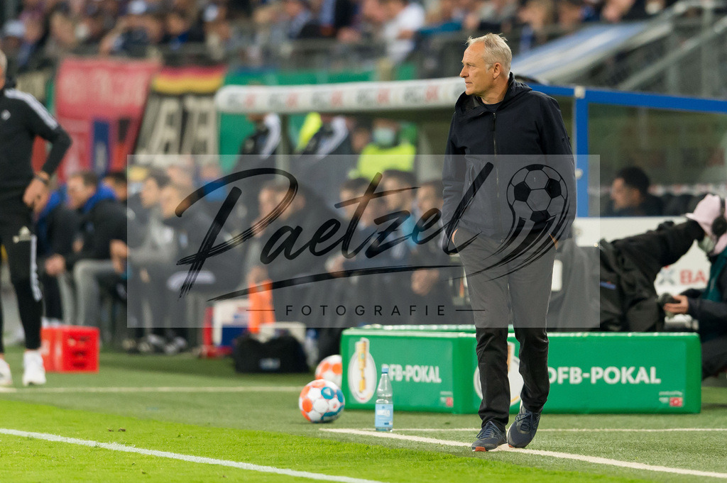 HSVSCF20220419_315 | Fussball, Herren: Trainer Christian Streich (SC Freiburg) schaut beim DFB-Pokal-Halbfinalspiel zwischen Hamburger SV und SC Freiburg im Volksparkstadion am 19.04.2022 in Hamburg, Deutschland.DFB / DFL REGULATIONS PROHIBIT ANY USE OF PHOTOGRAPHS AS IMAGE SEQUENCES AND/OR QUASI-VIDEO. - Realisiert mit Pictrs.com