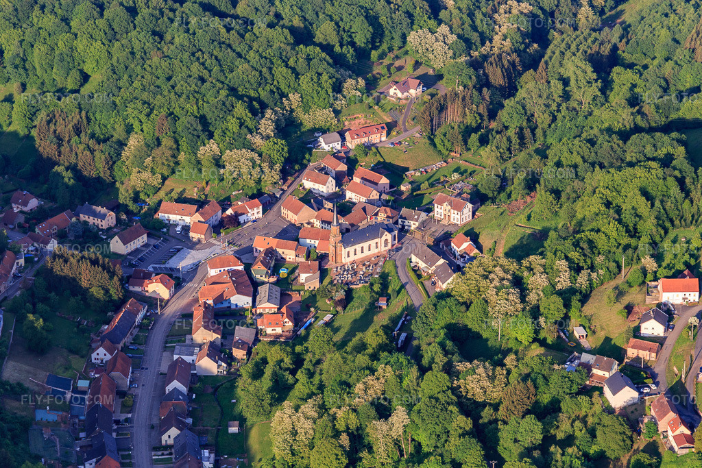 Aerial view: Eglise Saint Pierre in the village center in Hottviller in the state Moselle, France. – Photo: IMG_107223.jpg taken on 05/18/2018 by Werner Riehm/FLY-FOTO.com – Resolution of the original: 5193 x 3462 px – Archiprêtré de Bitche - Diocèse de Metz