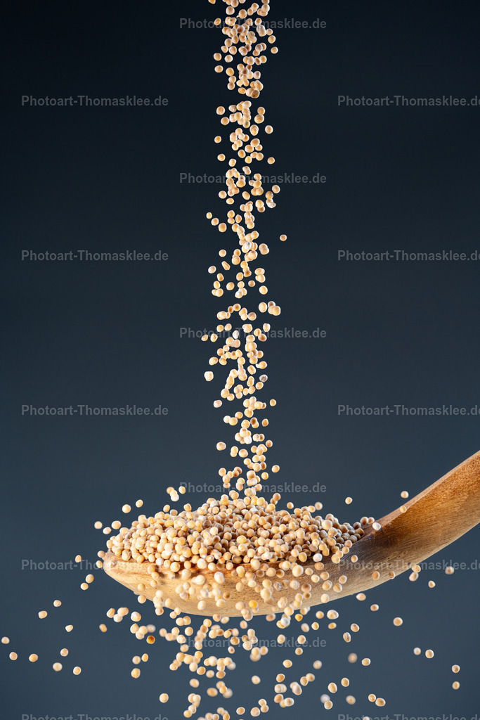Goldene Körner – die Kraft des Senfs | Goldene Körner – die Kraft des Senfs. Kollektion: A spoon of tastefully seasonings.In dieser ausdrucksstarken Studioaufnahme fallen unzählige kleine, ganze Senfkörner dynamisch auf einen rustikalen, alten Holzlöffel. Die Bewegung der Körner wurde mit Highspeed-Blitzen eingefroren, wodurch jedes einzelne Korn klar und detailreich sichtbar ist. Der dunkle blaugraue Hintergrund mit sanftem Verlauf bildet einen eleganten Kontrast zur warmen, goldgelben Farbe der Senfkörner. Die rustikale Struktur des Holzlöffels verstärkt die natürliche Anmutung der Szene. Dieses Motiv kombiniert Dynamik und Authentizität und eignet sich perfekt für kulinarische Themen, Foodstyling oder stilvolle Wanddekorationen im Bereich Küche und Gastronomie.Wo könnte man dieses Bild am besten aufhängen?Moderne Küchen oder Wohnküchen – als stilvolles Element zur Betonung von natürlichen Lebensmitteln.Feinkostläden oder Gewürzgeschäfte – um Authentizität und Qualität der angebotenen Produkte visuell zu unterstützen.Restaurants oder Bistros – insbesondere solche mit Fokus auf regionale Küche oder Slow Food Konzepte.Alu-Dibond: Die matte und zugleich elegante Oberfläche sorgt für satte Farben und eine moderne, hochwertige Anmutung – perfekt für stilvolle Küchen oder moderne Gastronomiebetriebe.Acrylglas: Durch die glänzende Tiefe und hohe Farbbrillanz erscheinen die Körner fast greifbar und die feinen Details kommen hervorragend zur Geltung – ideal für edle Präsentationen.Poster: Ein großformatiges Poster erhält die Dynamik und Lebendigkeit der fallenden Senfkörner, bietet aber eine flexible und kostengünstige Dekorationsmöglichkeit.Leinwand: Die Textur der Leinwand unterstreicht die Natürlichkeit und die rustikale Stimmung des Motivs und passt wunderbar zu wohnlichen oder ländlich inspirierten Einrichtungsstilen. - Realisiert mit Pictrs.com
