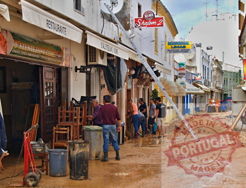 Community volunteers cleaning up after flood disaster | Albufeira Flood - discruction by weather problems Volunteers and workers cleaning muddy street and businesses after flood damage in a European town - Realisiert mit Pictrs.com