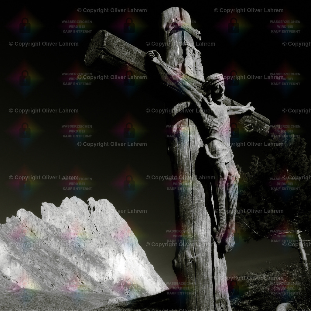 Berge und Glauben | Ein altes Kruzifix aus Holz steht vor einer der Geisler Spitzen in den Südtiroler Dolomiten. 