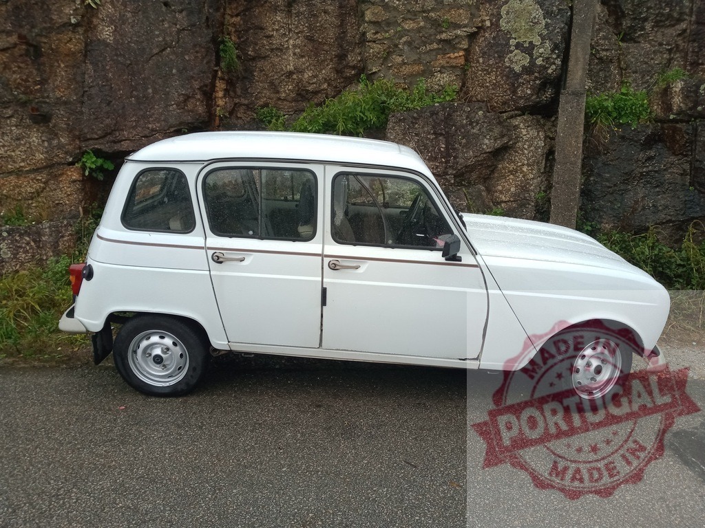Renault 4 car parked alongside rock wall | White Renault 4 classic hatchback parked on a wet road next to a stone wall - Realized with Pictrs.com