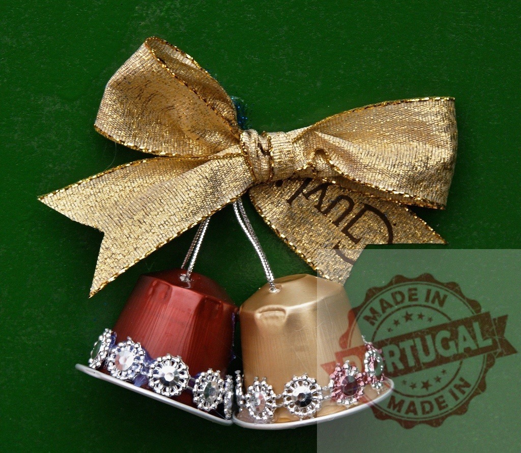 Christmas bells made with recycled Nespresso capsules hanging from golden ribbon | Two Christmas bells made with recycled Nespresso capsules hanging from golden ribbon on green background - Realized with Pictrs.com