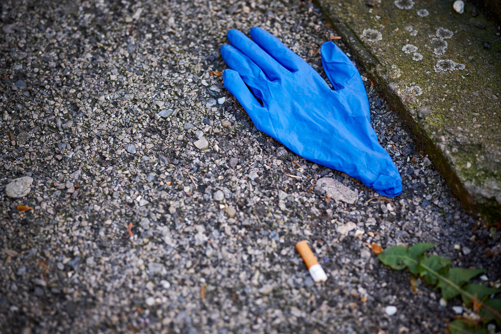 Blauer Einweghandschuh liegt auf dem Boden | Wien, Austria - April 07, 2020: Fotografische Eindrücke auf dem Weg von Floridsdorf zum Stephansplatz während der Corona-Krise; Blauer Einweghandschuh liegt auf dem Boden. - Realisiert mit Pictrs.com