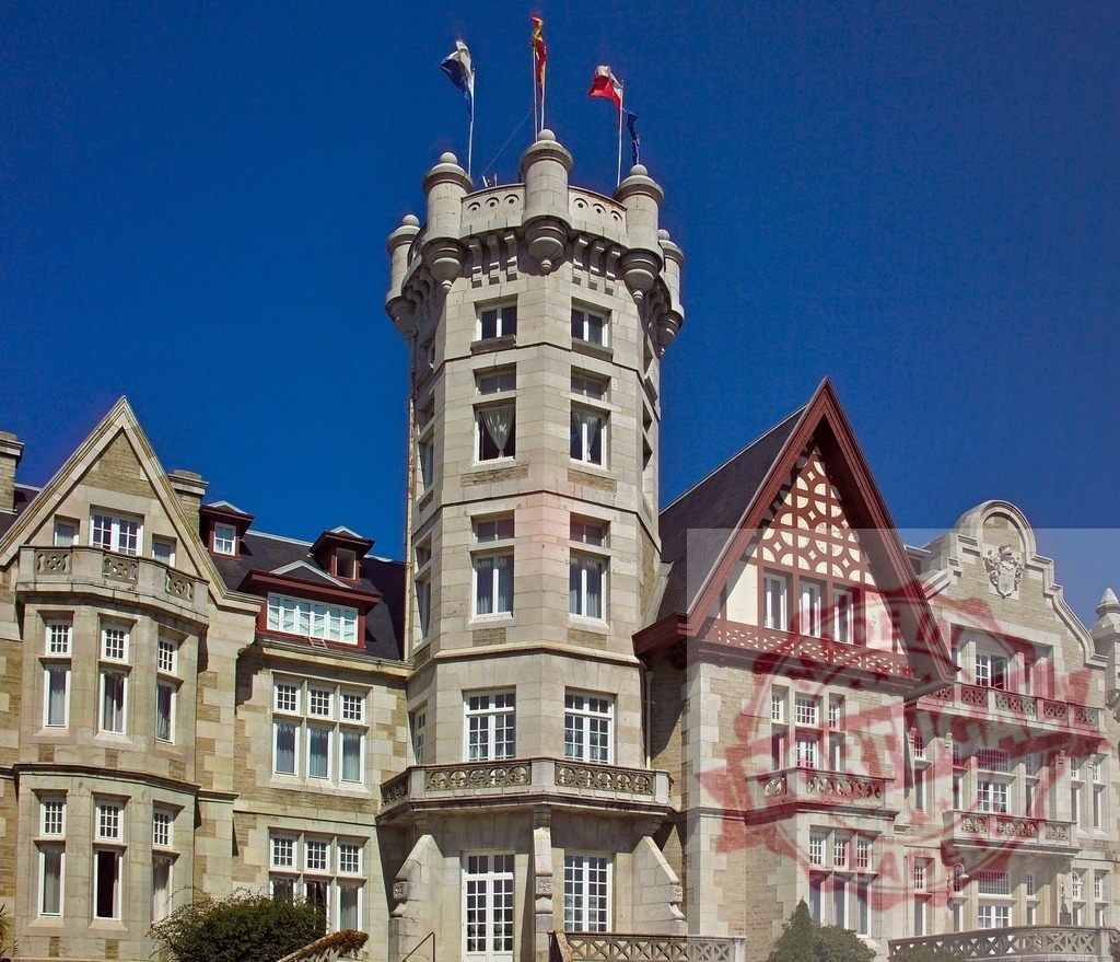 Palacio de la Magdalena tower against clear blue sky in Santander. Spain - Cantabria | Palacio de la Magdalena showing its main tower with flags under a clear blue sky - Realized with Pictrs.com