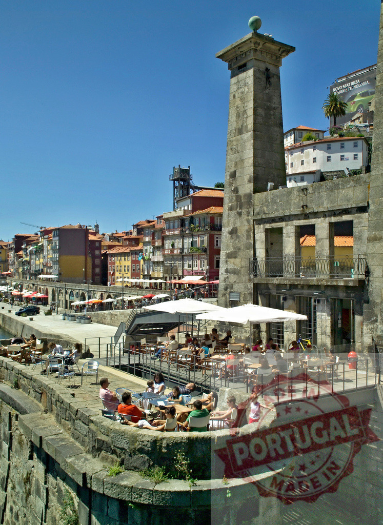 Ribeira quarter Porto Portugal with people relaxing at riverside cafes | People enjoying sunny day at outdoor cafes along the Douro river in Porto's historic Ribeira - Realized with Pictrs.com