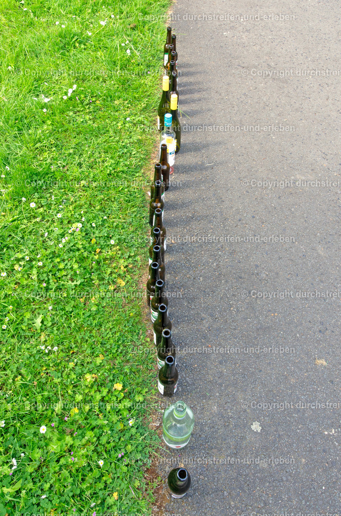 Wie eine Menschenschlange von oben, aber nur Bier- und Weinflaschen am Vatertag | Wie Menschen reihen sich an Christi Himmelfahrt Bier und Weinflaschen aneinander. Dafür sorgten Feiernde in Gievenbeck.  - Realisiert mit Pictrs.com