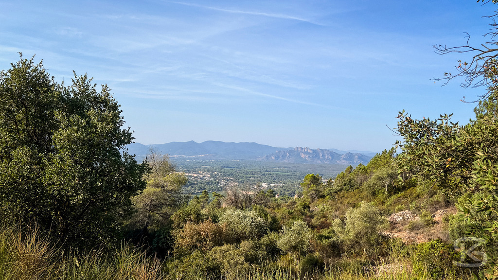 Blick auf den Rocher de Roquebrune im Hinterland von Fréjus – Provence | Panorama-Aussicht von bewaldeten Hügeln über das Tal von Fréjus auf das markante Felsmassiv Rocher de Roquebrune unter einem klaren blauen Himmel in Südfrankreich. - Realisiert mit Pictrs.com