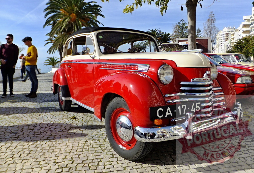 Shiny red and white Opel Olympia Rekord parked on cobblestone street | Classic red and white Opel Olympia Rekord parked on a cobblestone street, evoking nostalgia for vintage automobiles - Realisiert mit Pictrs.com