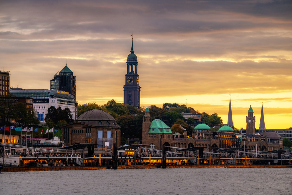 10251101 - Michel und Landungsbrücken im Morgenlicht | Blick auf den Michel und die Landungsbrücken vor einem goldfarbenen Himmel bei Sonnenaufgang.