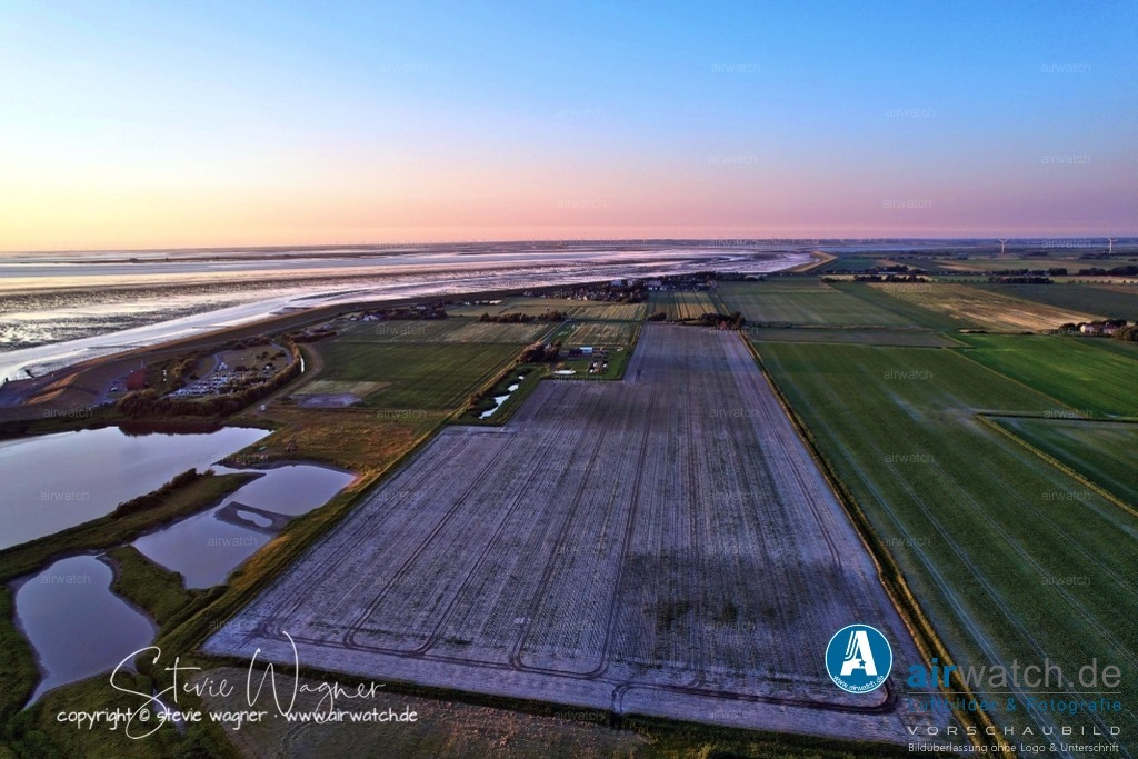Luftbild Nordstrand, LangerDeich, Dreisprung, Püttenweg, Trendermarsch, Westen, Fuhlehörn, Husumer Bucht | Luftbild Nordstrand, LangerDeich, Dreisprung, Püttenweg, Trendermarsch, Westen, Fuhlehörn, Husumer Bucht - Nordstrand ist eine Marschinsel in Schleswig-Holstein an der deutschen Nordseeküste und Teil des UNESCO-Weltnaturerbes Wattenmeer. Die Insel ist bekannt für ihre ruhige, grüne Landschaft, weite Felder, Salzwiesen und einen gut erhaltenen Naturraum, der ideal für Erholung und Naturliebhaber ist. Das „Grüne Wegshörn“ bezeichnet eine Landzunge oder eine charakteristische Stelle auf Nordstrand, die landschaftlich hervorsticht und möglicherweise Teil eines Wanderwegenetzes ist, das durch die unberührte Marsch führt.