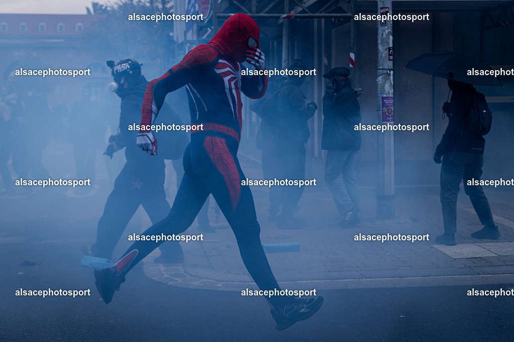 9L6A6675 | Strasbourg, France, 24 octobre 2026. Des manifestants affrontent les forces de l’ordre lors d’une mobilisation dans le centre-ville de Strasbourg. Des policiers interviennent pour disperser des groupes de manifestants, tandis que des gaz lacrymogènes sont utilisés. Des affrontements, des jets de projectiles et des dégradations sont observés dans plusieurs rues. Des barricades et des véhicules en feu témoignent de la tension qui règne en marge de la mobilisation. - Realisiert mit Pictrs.com