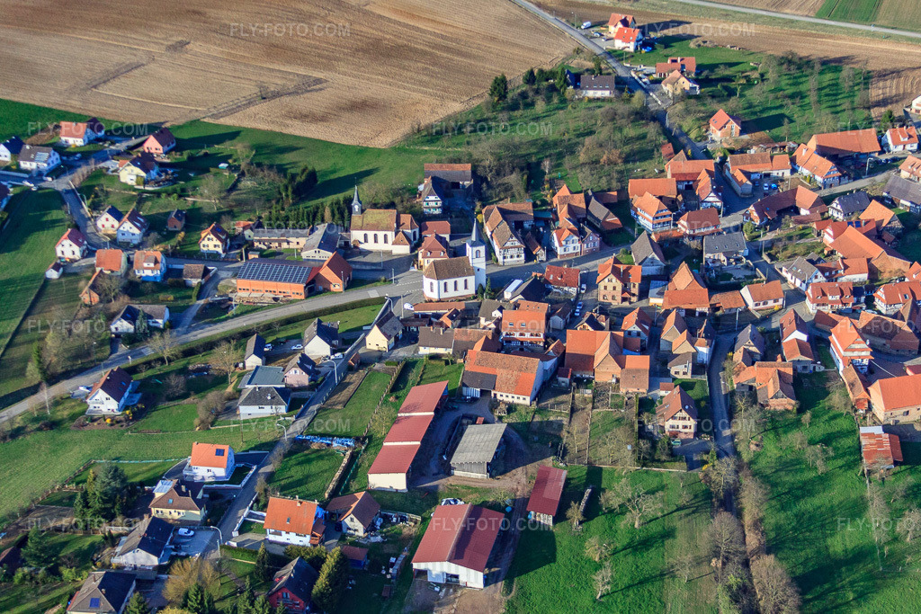 Aerial view: Village with Catholic Church of Saint George and Protestant Church of the South in Keffenach in the state Bas-Rhin, France. – Photo: IMG_38757.jpg taken on 03/20/2011 by Werner Riehm/FLY-FOTO.com – Resolution of the original: 4541 x 3028 px