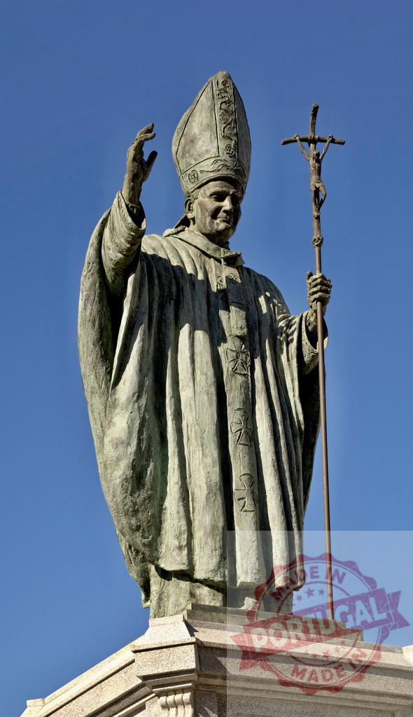 Pope John Paul II bronze statue blessing under blue sky. Espana - Cadiz | Holy Pope John Paul II statue blessing, representing faith, Catholicism, and religious devotion - Realisiert mit Pictrs.com