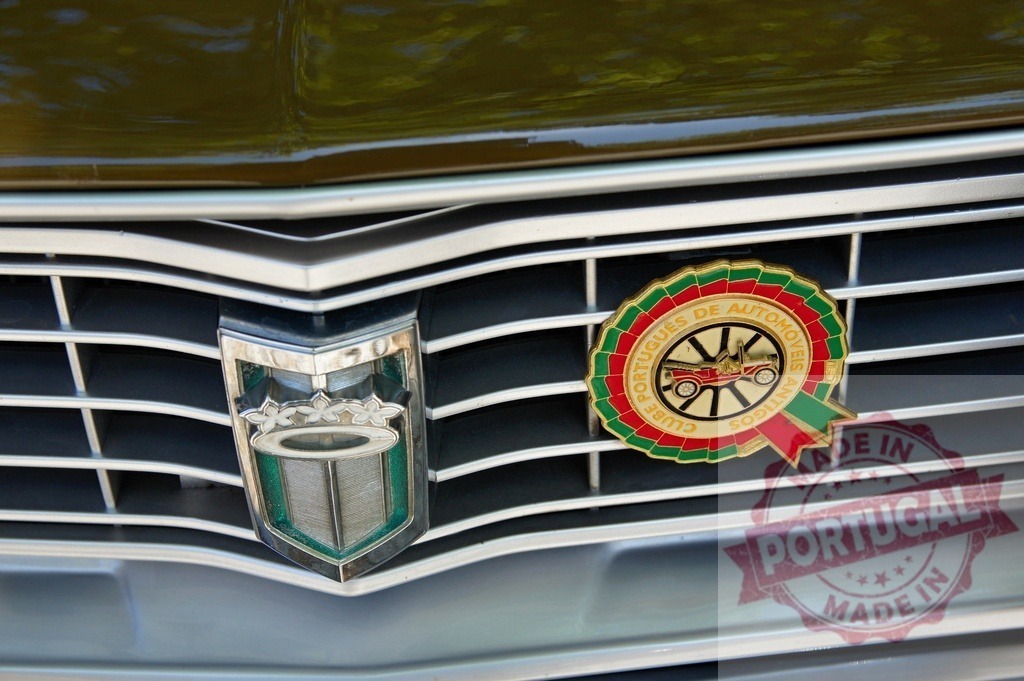 Classic car grille showcasing Clube Português de Automóveis Antigos badge | Close-up of a vintage car's front grille, featuring manufacturer's emblem and Clube Português de Automóveis Antigos badge, highlighting classic car enthusiasm - Realisiert mit Pictrs.com
