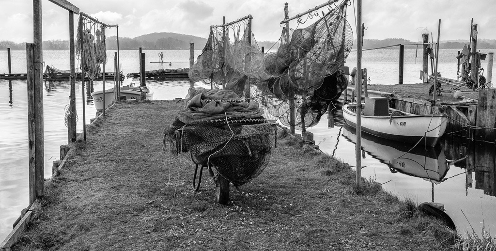 fischer-2020-017 | Die Landungsbrücken am Holmer Strand sind grasbewachsene Anleger der Schleswiger Fischer. Hier machen sie seit Jahrhunderten ihre Boote fest und lagern ihr Material. Durch schwimmende Pontons sind einige der Landungsbrücken im Laufe der Zeit erweitert worden. - Realisiert mit Pictrs.com