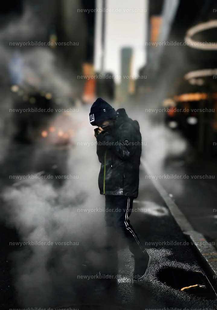 Mystische Straßenmomente in Midtown Manhattan | Ein Junge steht mitten in Midtown Manhattan, umgeben von dem ikonischen Dampf, der aus den Tiefen der Stadt aufsteigt und die Straßen in eine geheimnisvolle Aura hüllt. Die Lichter der Wolkenkratzer brechen sich im spiegelnden Wasser auf dem Asphalt, als hätte die Stadt selbst ein Gemälde geschaffen. Dieses Bild fängt die Essenz von New York ein – die Mischung aus Energie, Unruhe und Schönheit, die sich in jeder Ecke verbirgt. Der Dampf wirkt wie ein Schleier, der die Realität verschwimmen lässt, während die Reflexionen auf dem nassen Boden eine fast surreale Dimension eröffnen. Es ist ein Moment, der die Seele der Metropole spürbar macht: das Zusammenspiel von Licht, Schatten und Bewegung, eingefangen in einer Szene, die sowohl rau als auch poetisch ist. Wer dieses Bild betrachtet, spürt die pulsierende Kraft der Stadt und die stille Magie, die sich in den kleinen Details offenbart.