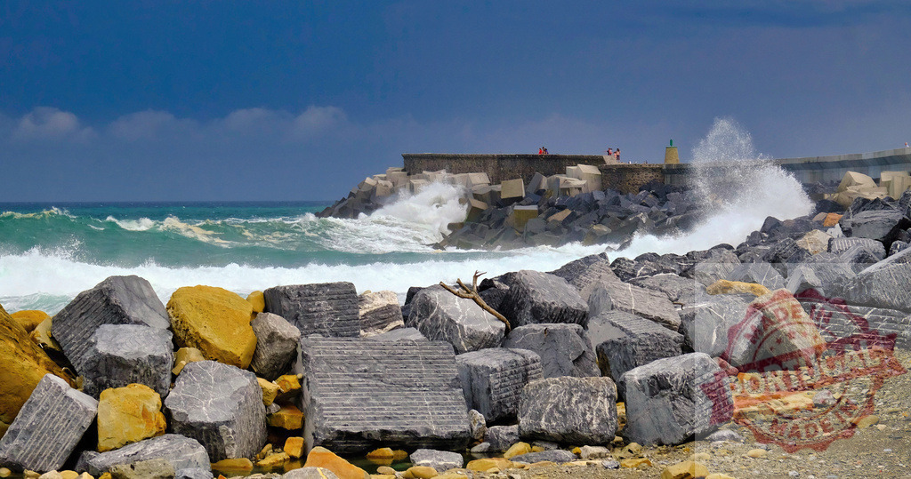 Ocean waves crashing on breakwater rocks under stormy sky | Crashing ocean waves create sea spray against a concrete and rock breakwater - Realized with Pictrs.com