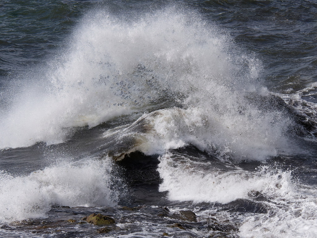 Gegenläufige Wellen | Eine Brandungswelle trifft auf eine Welle, die von der Felsenküste zurückgeworfen wurde. - Realisiert mit Pictrs.com