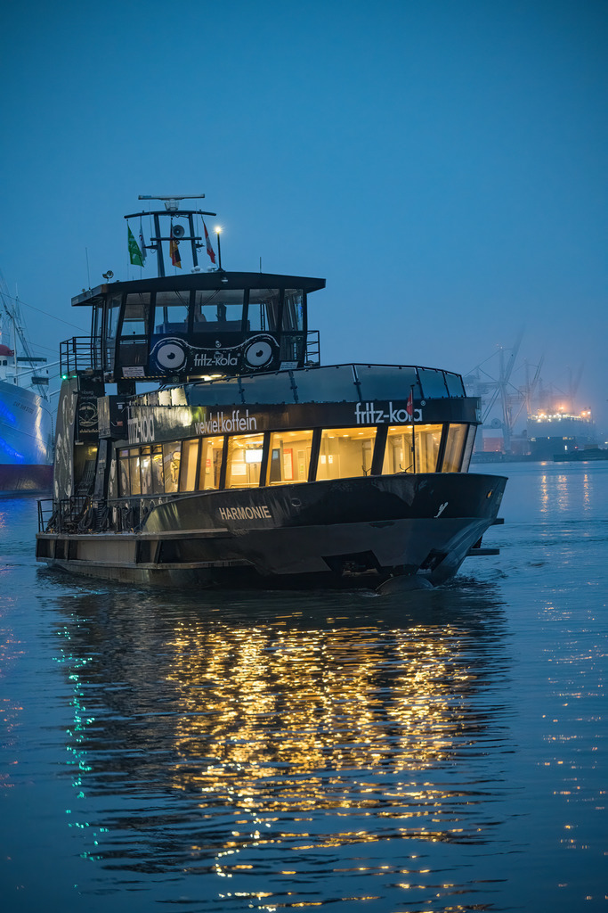 Hafenfähre auf der Elbe zur blauen Stunde | Eine Hamburger Hafenfähre auf der Elbe während der blauen Stunde, eingefangen zwischen ruhigem Wasser und urbaner Hafenbeleuchtung. - Realisiert mit Pictrs.com