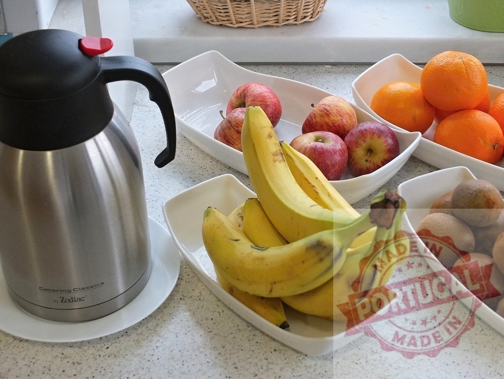 Healthy fresh fruit and hot drinks for breakfast buffet | Assortment of fresh fruit and a thermos of hot beverage on a breakfast buffet counter - Realisiert mit Pictrs.com
