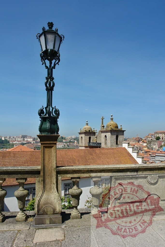 Porto cityscape with ornate street lamp and old town views. Porto - Portugal | Ornate street lamp standing over a scenic cityscape of Porto, Portugal under blue sky - Realized with Pictrs.com