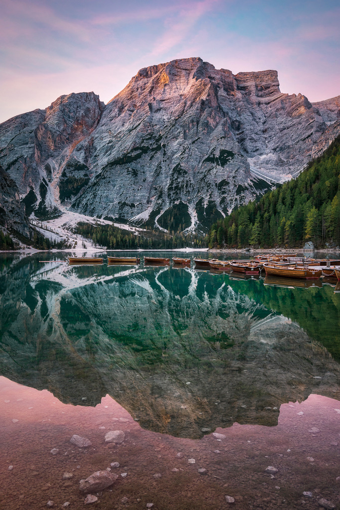 Stille am Morgen – Sonnenaufgang am Pragser Wildsee | Die ersten Sonnenstrahlen tauchen die Bergwelt rund um den Pragser Wildsee in warmes Licht. Das türkisfarbene Wasser liegt still, die Boote schlafen noch – ein Moment völliger Ruhe inmitten der Dolomiten. - Realisiert mit Pictrs.com