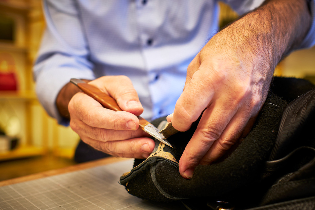 Albert Pattermann Wien | WIen, Austria - February 28, 2020; Albert Pattermann Wien; Thomas Hicker schneidet den Boden der Tasche, zwecks Reparatur heraus. - Realisiert mit Pictrs.com