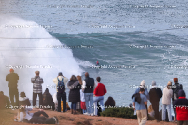 2025.01.25 xJAx Nazare_01063 Kopie | Nazare, Portugal Praia do Norte am 25. Januar 2025,  Surfer und die großen Wellen von Nazare in Portugal sind vom „Canhao de Nazare“ aus zu sehen v.l., Touristen am Leuchtturm von Nazare mit Blick auf den Nordstrand, im Hintergrund ein Surfer - Realisiert mit Pictrs.com