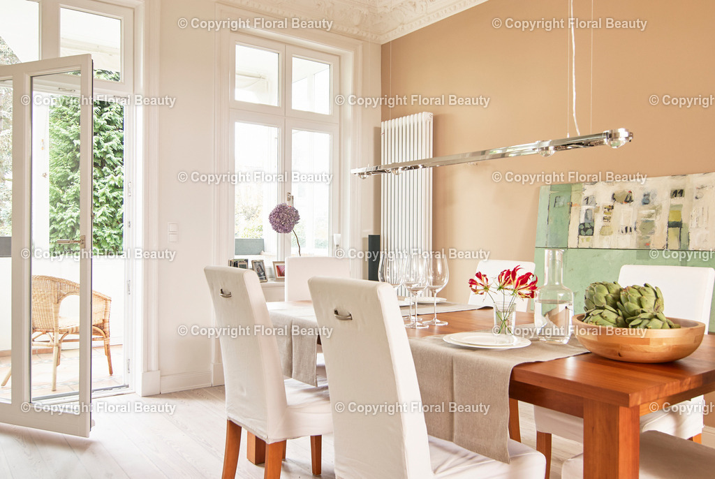 Esszimmer | Esstisch mit weißen Stühlen mit offener Balkontür. Beige Wandfarbe. Schale mit Artischocken auf dem Tisch. - Realisiert mit Pictrs.com