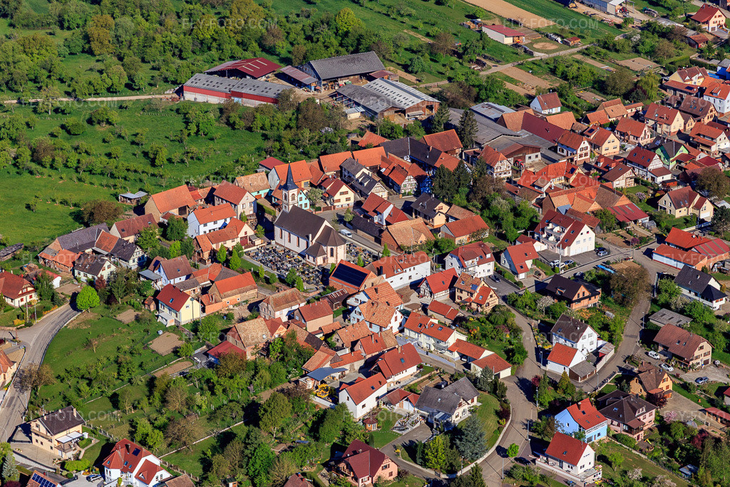 Aerial view: Cemetery and church in the village center in Forstheim in the state Bas-Rhin, France. – Photo: IMG_099382.jpg taken on 04/30/2017 by Werner Riehm/FLY-FOTO.com – Resolution of the original: 5472 x 3648 px