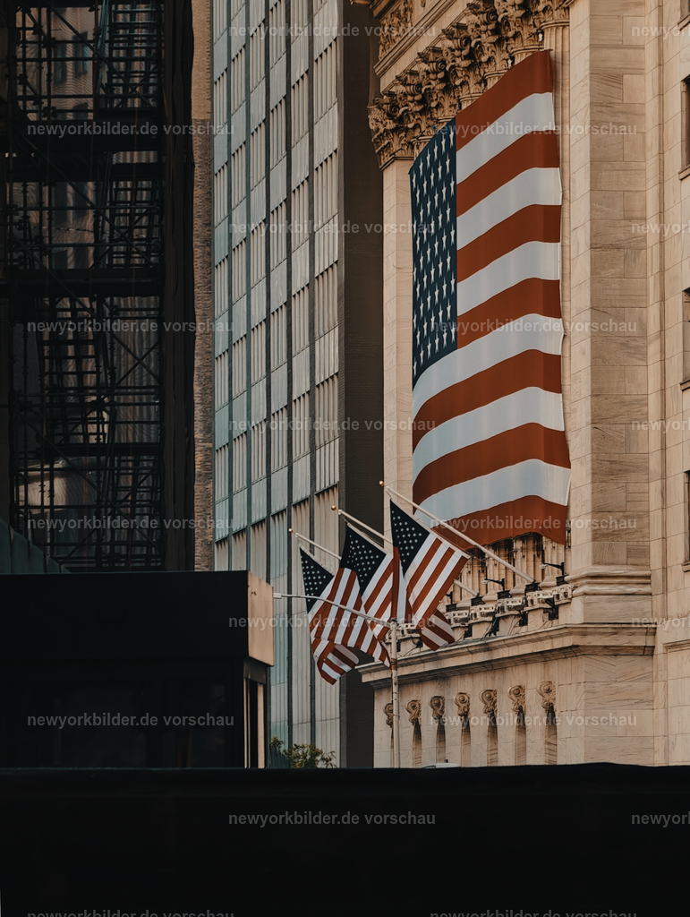 Memorial Day in Manhattan – Stolz und Flaggen an der Wall Street | Memorial Day in New York City – ein Wochenende voller Symbolkraft und Emotion. Die Straßen sind geschmückt mit amerikanischen Flaggen, und an der Wall Street weht eine besonders große, die den Stolz und die Geschichte des Landes repräsentiert. Dieses Foto fängt die Atmosphäre eines Feiertags ein, der mehr ist als nur ein freier Tag: Es ist ein Moment des Gedenkens und der Gemeinschaft. Die Kulisse von Downtown Manhattan mit ihren historischen Gebäuden und modernen Wolkenkratzern bildet den perfekten Rahmen für diese Szene. Memorial Day Weekend bietet in New York für jeden etwas – von Paraden über kulturelle Veranstaltungen bis hin zu ruhigen Momenten inmitten der Stadt. Die Kombination aus Architektur, Symbolik und sommerlicher Stimmung macht dieses Motiv zu einem Ausdruck von Tradition und urbanem Leben.