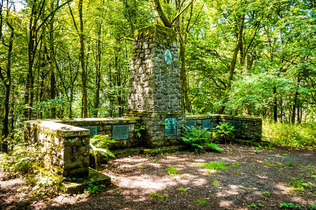 Walddenkmal - Schotten | Im Wetteraukreis stehen Mahnmale, die uns an die tiefen Wunden der Vergangenheit erinnern. Diese Denkmale tragen die Namen derer, die in Kriegen ihr Leben ließen – Menschen, die einst lebten, liebten und hofften. Als steinernen Zeuge erzählen sie von Trauer, Verlust und der Zerrissenheit einer Nation. Sie rufen uns dazu auf, innezuhalten und den Frieden zu bewahren. In ihrer Stille liegt ein tiefer, zeitloser Ruf nach Erinnerung und Versöhnung. - Realisiert mit Pictrs.com