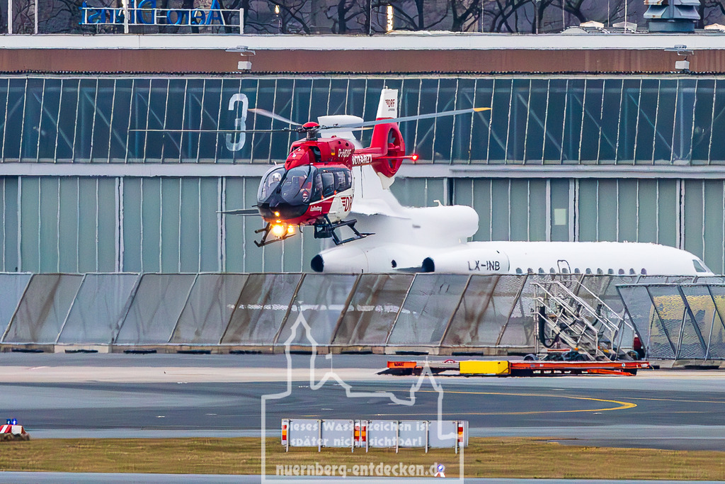 Albrecht Dürer Airport  Nürnberg, 15.03.2025 | Christoph Nürnberg der DRF Luftrettung, ein Airbus H145, schwebt in niedriger Höhe über dem Rollfeld des Albrecht Dürer Airport Nürnberg. Der Hubschrauber mit der Kennung "NOTARZT" ist auf dem Weg zu einem Einsatz. Im Hintergrund steht ein weißes Geschäftsflugzeug geparkt. Die Szene zeigt den aktiven Flugbetrieb und den Einsatz der Luftrettung. - Realisiert mit Pictrs.com