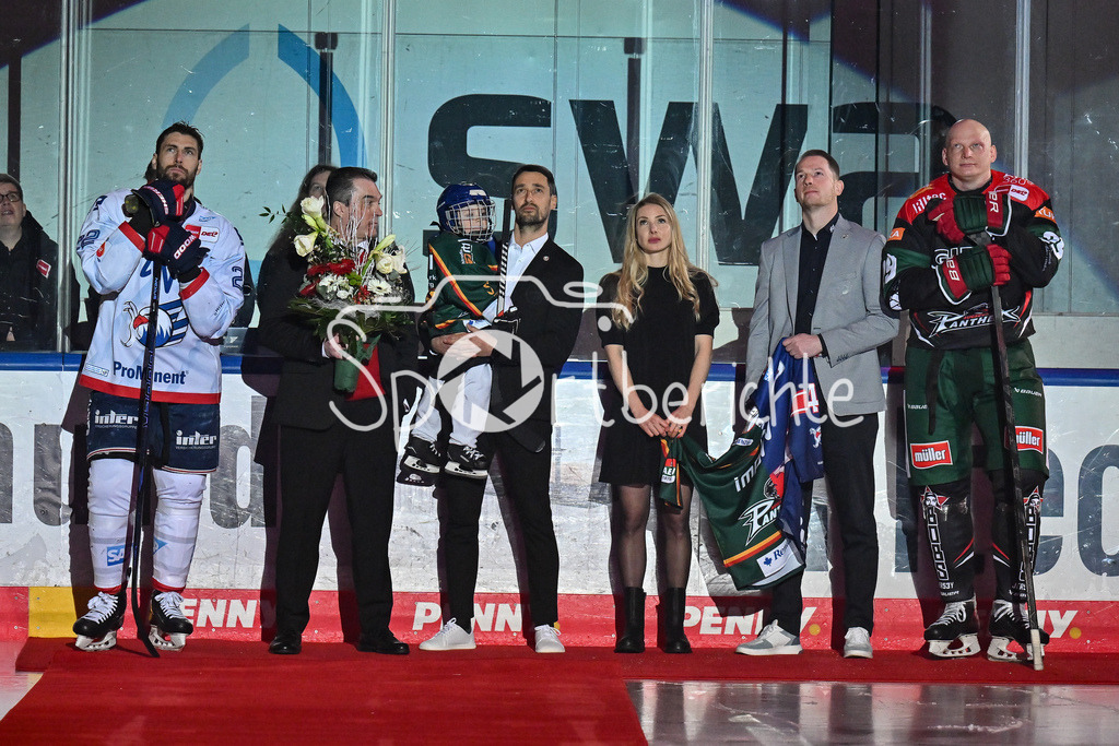 Augsburger Panther - Adler Mannheim | Dennis ENDRAS wird vor der Parite fuer seine Karriere geehrt / Ehrung / DEL: Augsburger Panther - Adler Mannheim, Curt Frenzel Stadion am 26.12.2024 / Denis REUL (Augsburger Panther #29) und Matthias PLACHTA (Adler Mannheim 22) bringen seinen Sohn aufs Eis