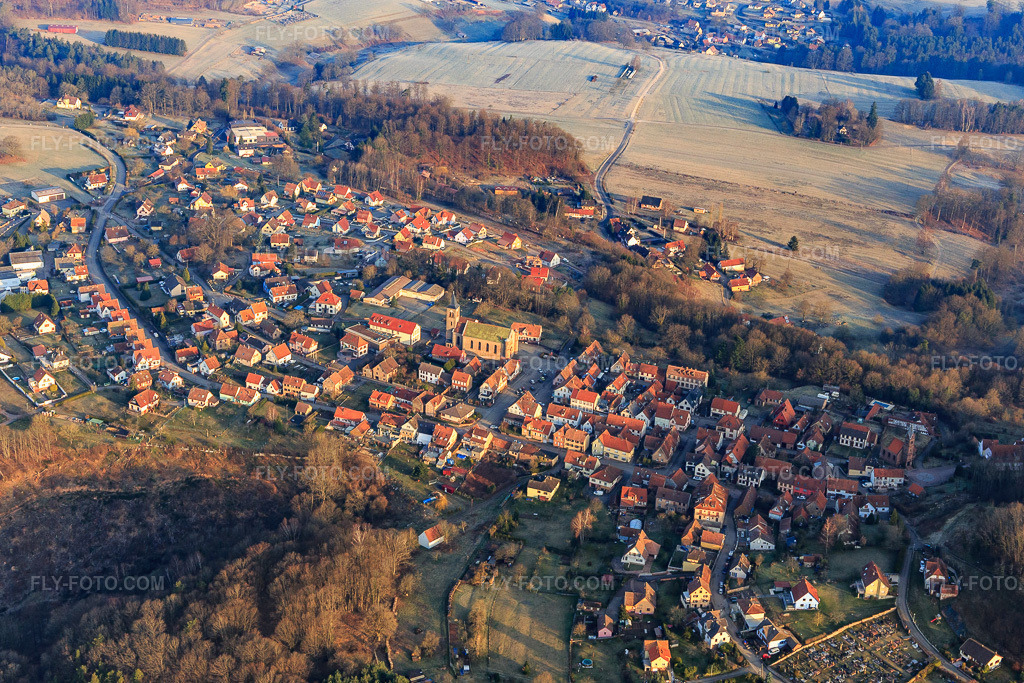 Aerial view: Village overview with Notre-Dame-Marie-Auxilliatrice church in Lichtenberg in the state Bas-Rhin, France.Photo: IMG_105281.jpg taken on 03/25/2018 by Werner Riehm/FLY-FOTO.comResolution of the original: 5111 x 3408 px