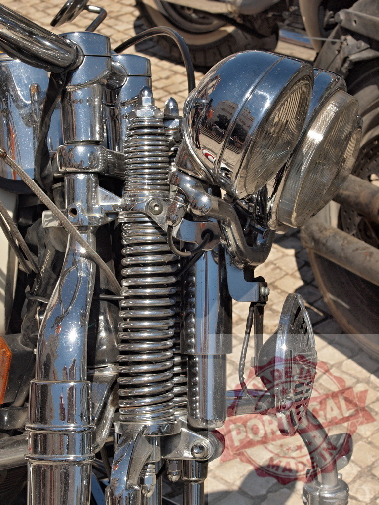 Chrome detailing on classic motorcycle front fork | Polished chrome parts and springs on a vintage motorcycle front end, parked outdoors - Realisiert mit Pictrs.com