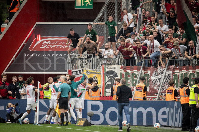 German Bundesliga, Bayer 04 Leverkusen vs. FC Augsburg, 18.04.2026 | LEVERKUSEN, GERMANY - APRIL 18, 2026 :  Fabian Rieder (FC Augsburg, 32) celebrates scoring his team's second goal with teammates  after a penalty in front of their fans during the German Bundesliga match on gameday 30 between Bayer 04 Leverkusen vs. FC Augsburg at BayArena on April 18, 2026 in Leverkusen, Germany. DFL REGULATIONS PROHIBIT ANY USE OF PHOTOGRAPHS AS IMAGE SEQUENCES AND/OR QUASI-VIDEO.