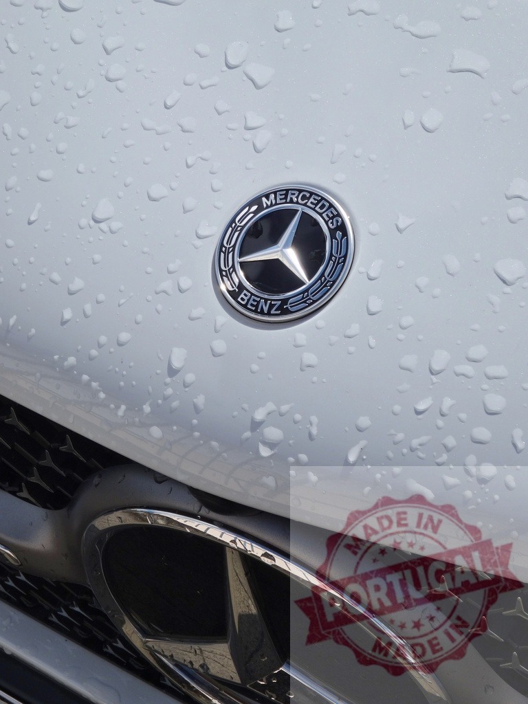 Mercedes Benz logo on wet luxury car hood | Mercedes Benz emblem covered in raindrops on a sleek vehicle hood - Realized with Pictrs.com