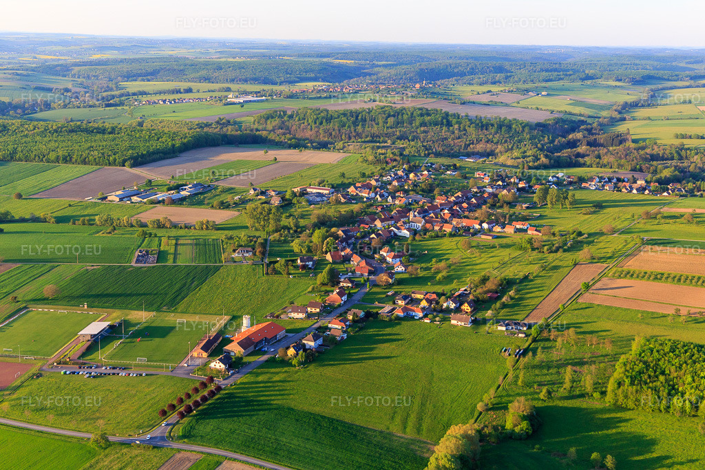 Vue aérienne: Vue du village depuis le sud-ouest avec le terrain de football de l'ASI Avenir à Adamswiller dans le département Bas Rhin, France – .Photo: IMG_145861.jpg prise le 30/04/2025 par Werner Riehm/FLY-FOTO.eu – Résolution de l'original: 5472 x 3648 px – ASI Avenir Section Football