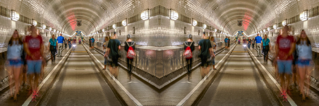 St.-Pauli-Elbtunnel | St.-Pauli-Elbtunnel in Hamburg, auch Alter Elbtunnel genannt. Er wurde 1911 eröffnet und ist rund 426 Meter lang. Durch eine längere Belichtungszeit der Aufnahme erhalten die Passanten eine dynamische Wirkung. — Das Bild wurde horizontal gespiegelt. Auflösung des Originals: 12030 x 4010 px. - Realisiert mit Pictrs.com