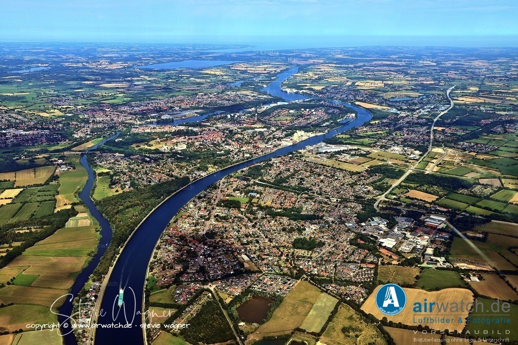 Luftbild Rendsburg - Die Stadt wurde 1253 erstmals als Stadt erwähnt | Die Stadt wurde 1253 erstmals als Stadt erwähnt, und um 1290 verlegte Graf Heinrich I. den Stammsitz seiner Familie von Itzehoe nach Rendsburg, wodurch die Grenzstadt zur gräflichen Residenz wurde. 1339 verlieh Graf Gerhard III. der Stadt Rendsburg eigene Gerichtsbarkeit und erweiterte Ländereien südlich der Eider, was die Stadt von der direkten Kontrolle des Burgvogts entzog.