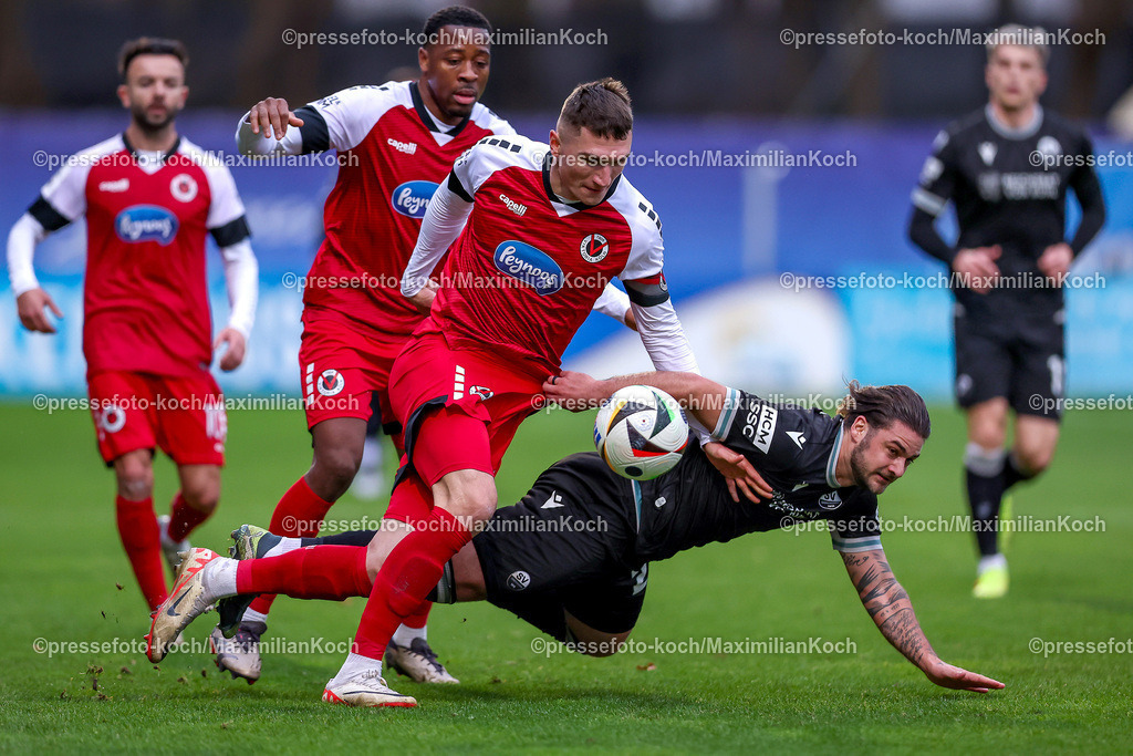 FCVK21122401027 | 21.12.2024, Fußball, FC Viktoria Köln – SV Sandhausen, 3.Liga, Sportpark Höhenberg, Saison 2024 2025: Christoph Greger (Viktoria Köln #15) und Enrique Lofolomo (Viktoria Köln #14) im Zweikampf gegen Dominic Baumann (Sandhausen #28)DFB regulations prohibit any use of photographs as image sequences and or quasi-video.