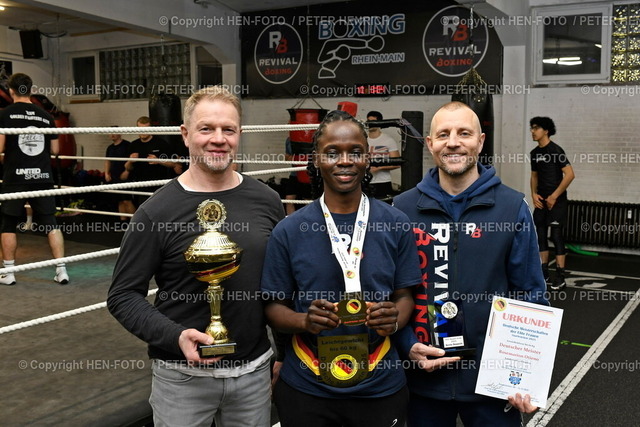Weiterer Titel für TG 75 DA | 18.12.2025 Gruppenfoto mit Abteilungsleiter und Sport-Ökonom Christian Bugge und der Deutschen Meisterin Rosemarion Otieno in Elite Frauen Leichtgewicht (bis 60kg) plus Beste Boxerin sowie Trainer Eugen Rempel (Foto: Peter Henrich) - Realisiert mit Pictrs.com