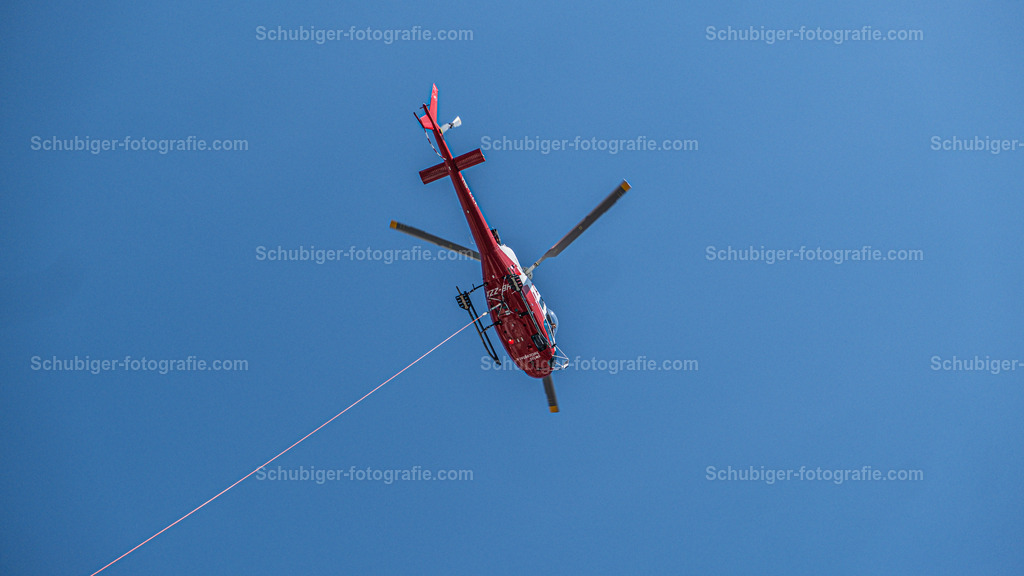 Helikopter im Einsatz | roter Helikopter der Gegenstände Transportiert - Realisiert mit Pictrs.com