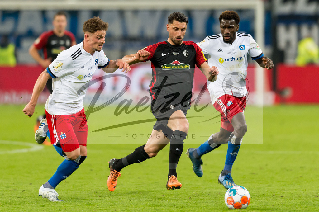 HSVSCF20220419_398 | Fussball, Herren: Moritz Heyer (Hamburger SV), Vincenzo Grifo (SC Freiburg) und Bakery Jatta (Hamburger SV) im Zweikampf beim DFB-Pokal-Halbfinalspiel zwischen Hamburger SV und SC Freiburg im Volksparkstadion am 19.04.2022 in Hamburg, Deutschland.DFB / DFL REGULATIONS PROHIBIT ANY USE OF PHOTOGRAPHS AS IMAGE SEQUENCES AND/OR QUASI-VIDEO. - Realisiert mit Pictrs.com