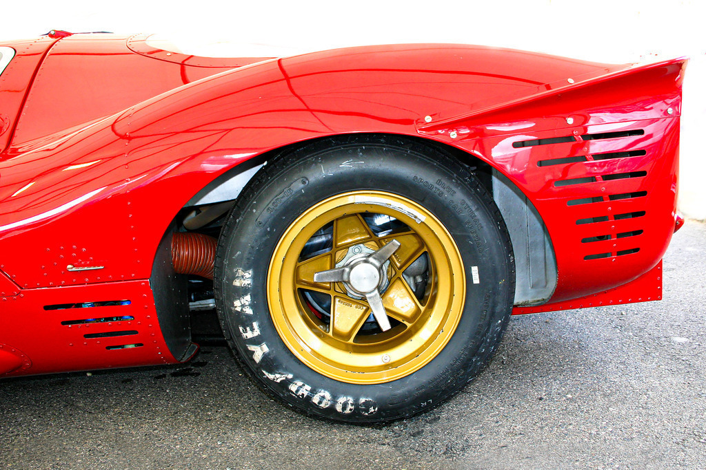 Historischer Rennwagen in Rot und Gold | Das Motiv aus dem Motorsport zeigt das Heck eines historischen Rennwagens in einer knallroten Lackierung. Auf der goldenen Felge mit Zentralverschluß ist ein Goodyear-Slick montiert. Ein hochwertiges und dekoratives Wandbild in brillanter Druckqualität auf Acrylglas, Alu-Dibond, Leinwand und vielen weiteren Wandprodukten perfekte geeignet für Ihr Ambiente. - Realisiert mit Pictrs.com
