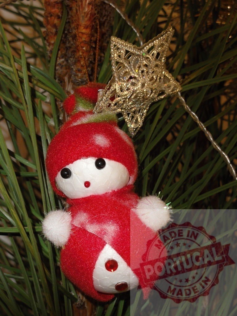 Red snowman Christmas ornament hanging on a pine tree branch with a golden star | Close-up of a festive red snowman ornament and a golden star hanging on a Christmas tree, spreading holiday cheer - Realized with Pictrs.com