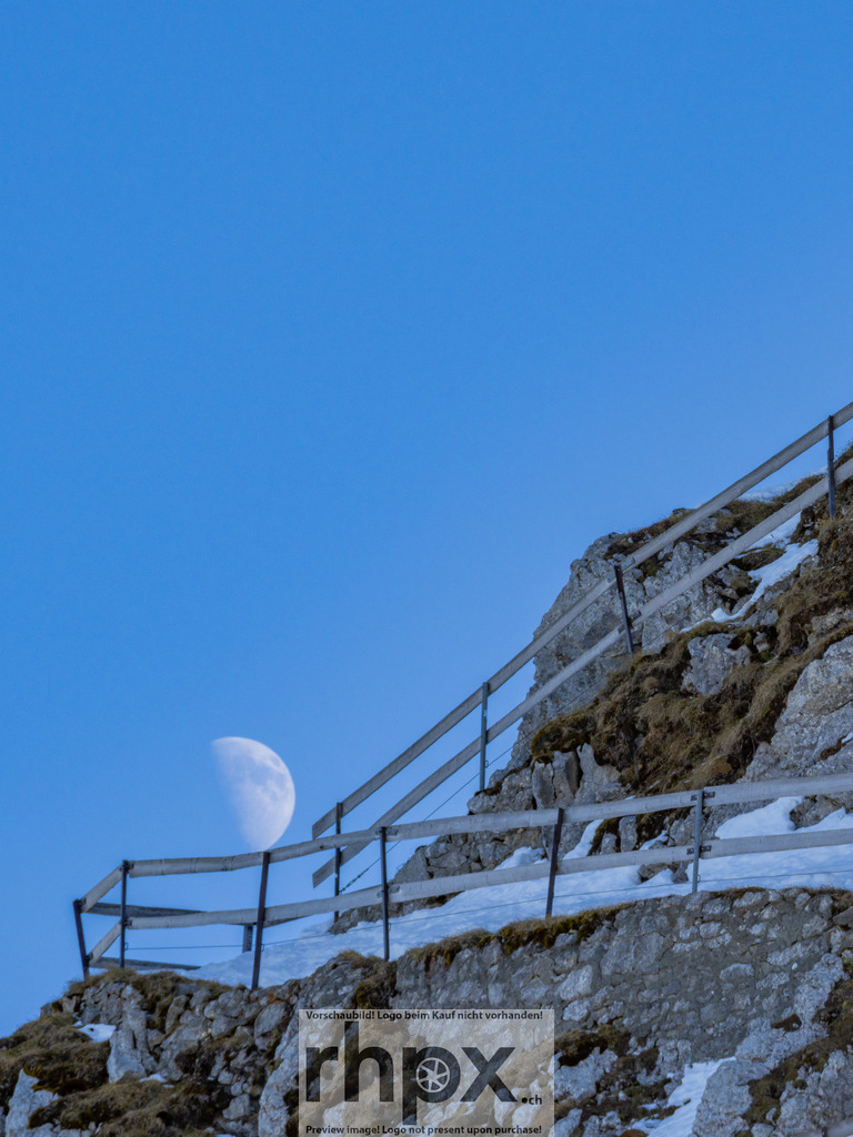 Mondaufgang am Pilatus Esel | <p><strong>Mond. Fels. Stille.</strong></p>
<p>Der blasse Tagesmond schiebt sich sanft hinter dem schroffen Grat des Esels hervor. Ein stilles Schauspiel am helllichten Tag, das die raue Schönheit der Innerschweizer Bergwelt auf minimalistische Weise unterstreicht.</p>
<p>Wähle unter "Produktauswahl" dein Wunschformat: Vom klassischen Wandbild über Puzzle & Tassen bis zum digitalen Download (z.B. als Handy-Hintergrund).</p>
<br> - Realisiert mit Pictrs.com