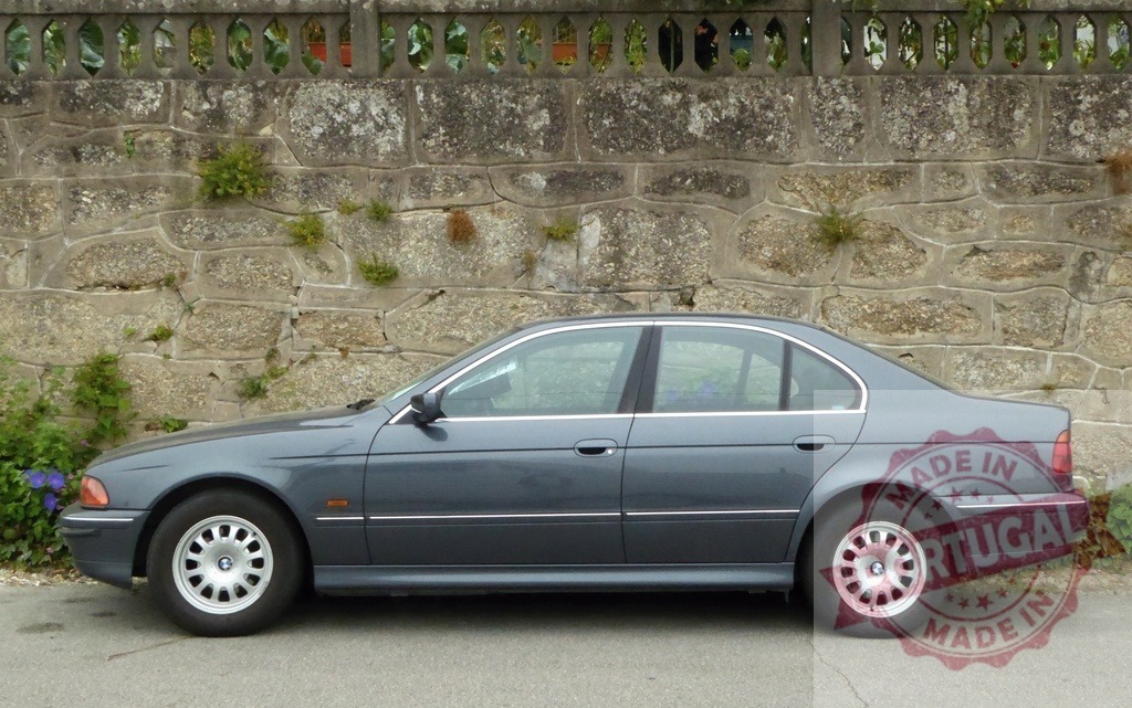 BMW 5 Series E39 sedan parked next to stone wall | BMW E39 gray sedan parked on a street next to an old stone wall - Realisiert mit Pictrs.com